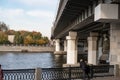 Supports of the Metro of the bridge across the Moskva river, metal fence of the embankment with granite pillars, watering, sunny