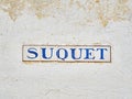 Suquet street signboard on a white stone wall. alella de Palafrugell, Spain