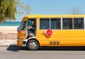 Yellow bus with driver in traditional Omani clothing look at cam, Oman