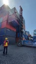 Surabaya, June 22th,an operator directing a stack container side loader at depot Royalty Free Stock Photo