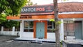 Surakarta, Central Java, Indonesia, July 23, 2022: The old post office building in orange color with a tree in front of the