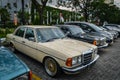 Ivory coloured Mercedes Benz 230 W123 on parking lot