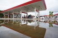 Gas station after rain, puddles forming reflections