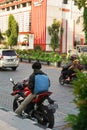 Surakarta, Indonesia - December 22, 2021: A red motorbike rider is stopping on the side of a solo city street while resting after Royalty Free Stock Photo