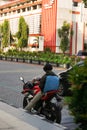 Surakarta, Indonesia - December 22, 2021: A red motorbike rider is stopping on the side of a solo city street while resting after Royalty Free Stock Photo