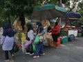 Surakarta, Indonesia - July 16th, 2022. Several moslem woman buying Typical food from the seller on the sidewalk in front of PGS.