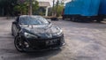 Black Toyota GT86 drifting on a closed parking lot taken from front view