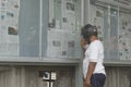 Surakarta, Indonesia - September 11, 2021: A pedicab driver is reading a newspaper containing the latest news in front of the nati