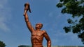 Surakarta, Indonesia, 20th June 2023, Statue of spirit of sport in a form of man holding torch against blue sky, Patung obor