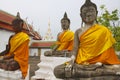 Three Buddha statues in front of the Wat Phra Borommathat Chaiya Ratcha Worawihan temple in Surat Thani, Thailand.