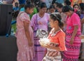 Burmese young girl dress in national costumes holding a bowl of food