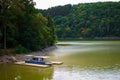 Sure river in Lultzhausen, Esch-sur-Sure, Luxembourg. Beautiful landscape with green mountains, a dock and a boat Royalty Free Stock Photo