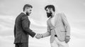 Sure sign you should trust business partner. Men formal suits shaking hands blue sky background. Business deal approved