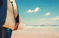 Surf board in surfer`s hand close up image with oceans waves vie