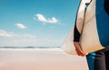 Surf board in surfer`s hand close up image with oceans waves vie