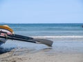 Surf-boat sitting at waters edge of ocean beach Royalty Free Stock Photo