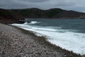 Surf on the coastline of the north sea with a mountainous coast in the background