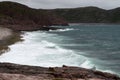 Surf on the coastline of the north sea with a mountainous coast in the background