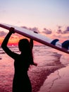 Surf girl with long hair go to surfing. Silhouette of a woman with surfboard on a beach at sunset or sunrise. Surfer and ocean Royalty Free Stock Photo