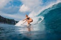 Surf girl at surfboard ride on barrel wave. Woman in ocean during surfing