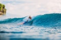 Surf girl on surfboard. Surfer woman dropped from surfboard and blue wave