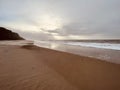 Surf on a lonely stretch of beach wrapped in soft morning light