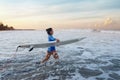 Surf In Ocean. Surfing Girl With Surfboard Walking Into Ocean. Young Surfer In Blue Wetsuit Going To Swim In Sea At Sunset. Royalty Free Stock Photo
