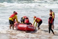 Surf rescue life savers training in progress. Surf rescue boat surrounded by crew and patient