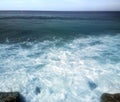 Surf on shores of Indian ocean and overgrown with algae stones