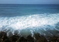 Surf on shores of Indian ocean and overgrown with algae stones