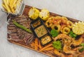 Surf and turf platter filled with grilled seafood and steaks accompanied by french fries and grilled vegetables. Royalty Free Stock Photo