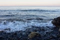 Surf on volcanic pebble beach Royalty Free Stock Photo