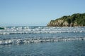 Surf waves roll in onto Main Beach, Mount Maunganui by Moturiki Island on summer day Royalty Free Stock Photo