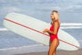 Surf woman with long blonde hair go to ocean.