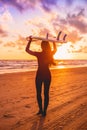 Surf woman with long hair go to surfing. Surfer with surfboard on a beach at sunset Royalty Free Stock Photo