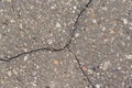A crack in the asphalt divides the surface into three parts