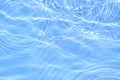 Surface of blue swimming pool water with light reflection. Texture of transparent blue water with waves in swimming pool Royalty Free Stock Photo