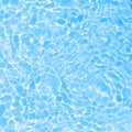 Surface of blue swimming pool water with light reflection. Texture of transparent blue water with waves in swimming pool Royalty Free Stock Photo