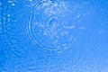 Surface of blue transparent swimming pool water texture with circles on the water. Trendy abstract nature background Royalty Free Stock Photo