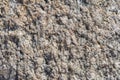 The surface of the chipped granite stone, rough, unpolished with multicolored splashes, natural, not treated, as a background for