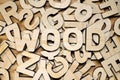 Surface covered with random wooden letters and word WOOD on top. Royalty Free Stock Photo