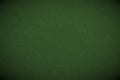 The surface of dark green cardboard. Paper texture with cellulose fibers. Paperboard wallpaper or background with vignetting. Royalty Free Stock Photo