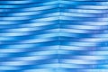 Surface, geometric pattern of the ends of thick glass. Blue glass background, diagonal lines and strips