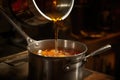 surface level shot of a steel ladle pouring mulled cider