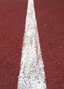 Surface perspective rubberized running track with white line