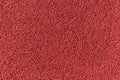 Red rubber pellets in treadmill athletics field texture abstract background