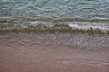 The surface is salty sea water, swaying in small waves near the shore, through the transparent bottom you can see stones Royalty Free Stock Photo