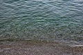 The surface is salty sea water, swaying in small waves near the shore, through the transparent bottom you can see stones Royalty Free Stock Photo