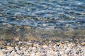 The surface is salty sea water, swaying in small waves near the shore, through the transparent bottom you can see stones Royalty Free Stock Photo