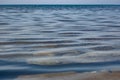 The surface is salty sea water, swaying in small waves near the shore, through the transparent bottom you can see stones Royalty Free Stock Photo